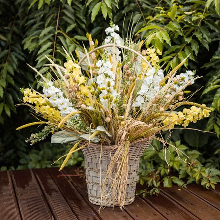 Composition in a basket with a delphinium